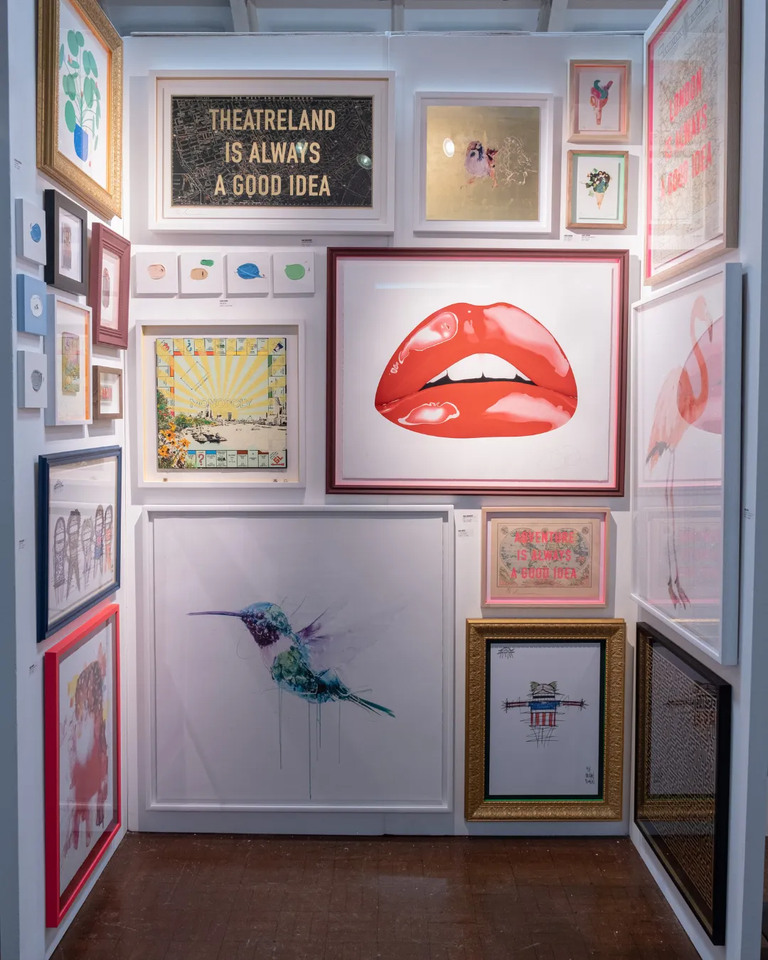 A small stand hung with framed prints including red lips and a sign reading Theatreland is always a good idea