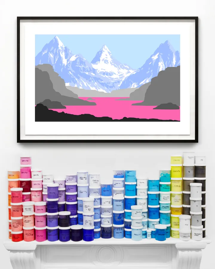 Framed print of pink and grey mountains above a shelf of paint pots