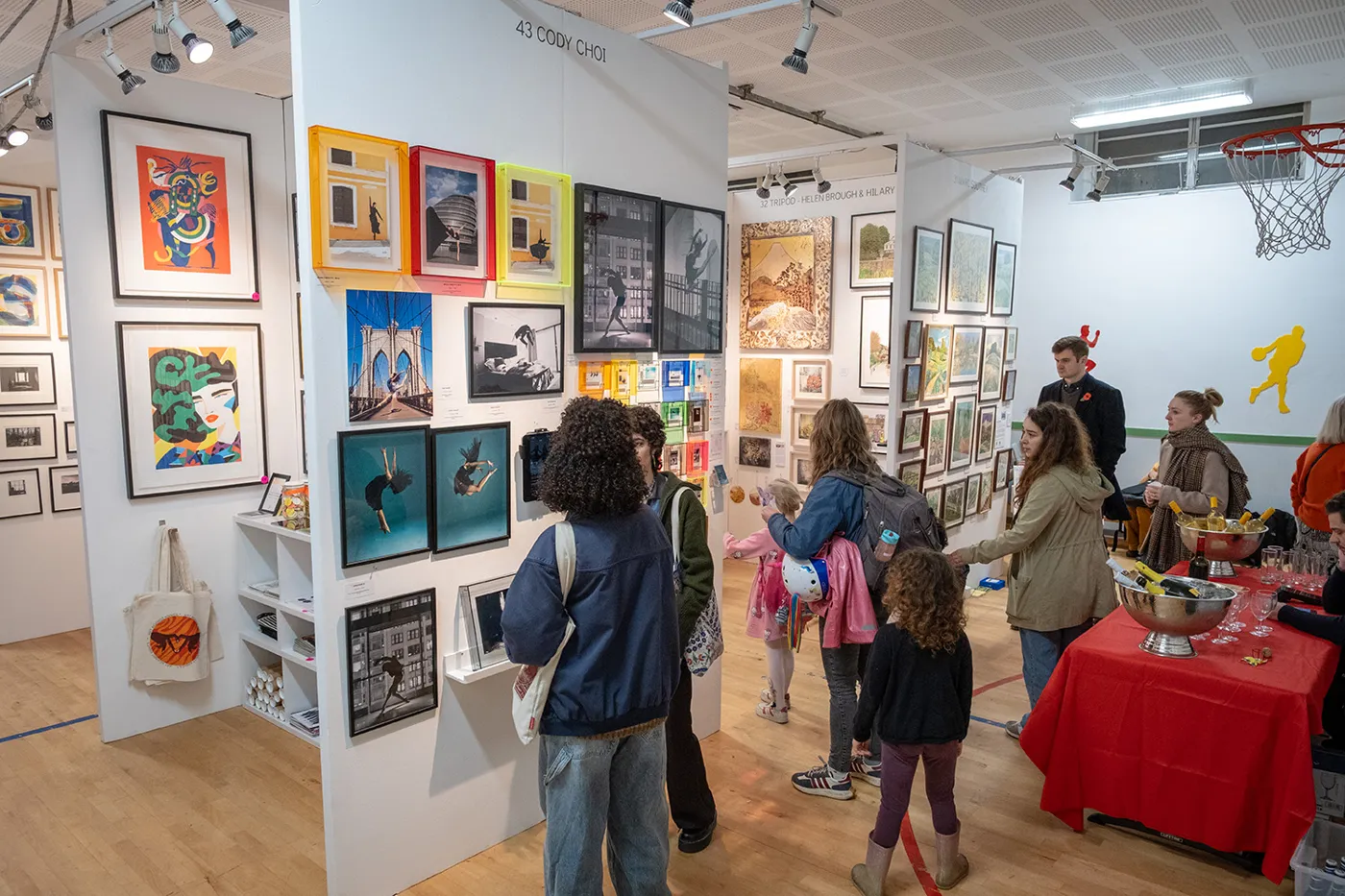 Families with children walking between stands of framed work